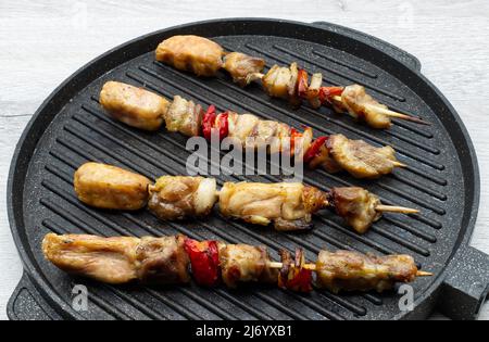 Fleisch auf Holzspießen auf dem Grill. Stockfoto