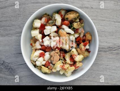Gemischte gefrorene Meeresfrüchte isoliert auf Holzhintergrund Stockfoto
