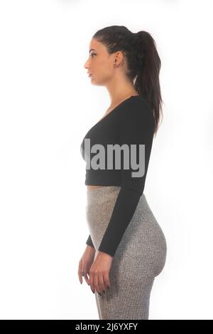 Frau in Leggings, die vor weißem Hintergrund absieht Stockfoto