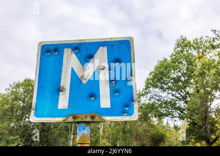 Einschusslöcher in einem Straßenschild für einen Treffpunkt Stockfoto