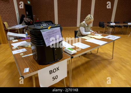 Mitarbeiter des Wahllokalen, die im Wahllokal des Agape Centre Belfast im Wahlkreis Belfast South Vorbereitungen treffen, da die Vorbereitungen vor der Eröffnung des Senders für die Wahlen zur nordirischen Versammlung 2022 laufen. Bilddatum: Donnerstag, 5. Mai 2022. Stockfoto