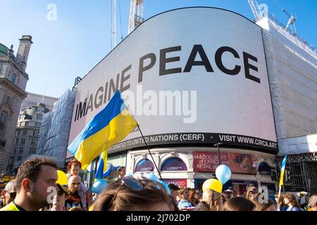 Yoko Ono's Imagine Peace-Botschaft an den Londoner Ständen mit der Protestkundgebung der Ukraine, Piccadilly Circus, London, Großbritannien. Stockfoto