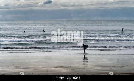 Sumner, Christchurch, Canterbury/Neuseeland - 18. März 2022: Surfer und Stand-up-Paddle-Boarder am Sumner Beach, Christchurch Stockfoto