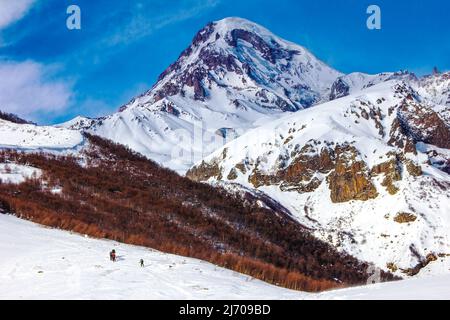Erstaunliche bunte Berglandschaft mit einer Gruppe von Kletterern in der Ferne. Georgien, Kaukasus, Ausläufer von Kasbek. Stockfoto