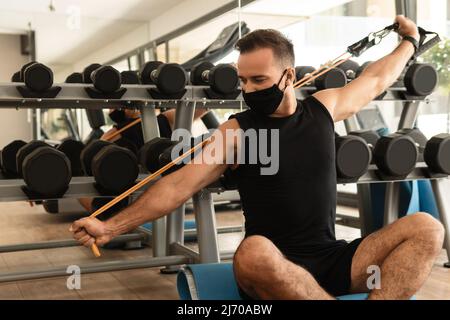 Ein Mann, der im Fitnessstudio mit einem Gummiband trainiert Stockfoto