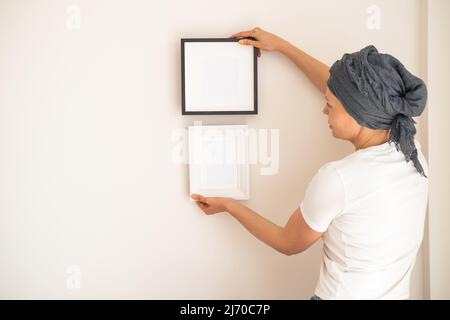 Ein Holzrahmen mit leerem Raum in den Händen der Frauen Stockfoto