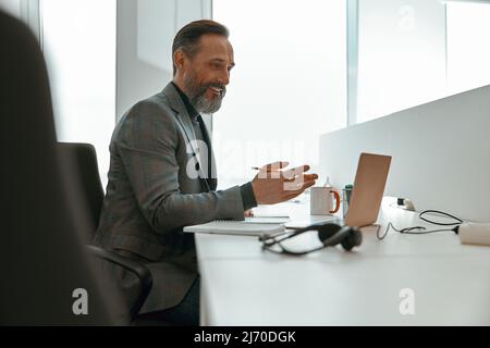 Kaukasischer Mann, der online in einem modernen Büro arbeitet Stockfoto