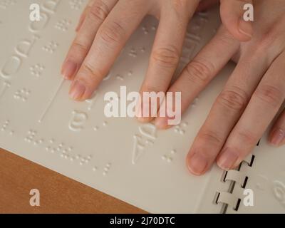 Eine Frau lernt das Braillealphabet mit einem Decoder. Stockfoto