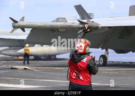 PHILIPPINE SEA (19. April 2022) Aviation Ordnanceman 3. Klasse Shianna Morris aus Baxly, Georgia, bewaffnet eine WDU-17/B-Rakete auf einer F/A-18E Super Hornet, die den 'Tophoattern' des Strike Fighter Squadron (VFA) 14 zugewiesen wurde, auf dem Flugdeck des Flugzeugträgers USS Abraham Lincoln (CVN 72) der Nimitz-Klasse. Die Abraham Lincoln Strike Group befindet sich im geplanten Einsatzgebiet der US-Flotte für 7., um die Interoperabilität durch Allianzen und Partnerschaften zu verbessern und gleichzeitig als reaktionsfähige Truppe zur Unterstützung einer freien und offenen Region im Indo-Pazifik-Raum zu dienen. (USA Navy Foto von Mass Communication Speci Stockfoto