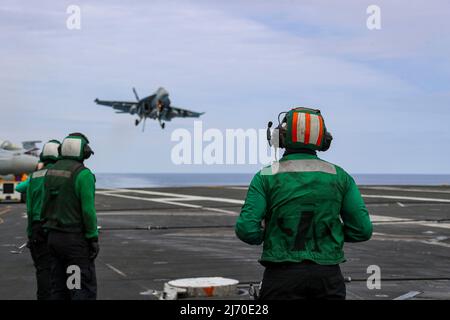 PHILIPPINISCHE SEE (19. April 2022) Seeleute beobachten den Flugbetrieb auf dem Flugdeck des Flugzeugträgers USS Abraham Lincoln (CVN 72) der Nimitz-Klasse. Die Abraham Lincoln Strike Group befindet sich im geplanten Einsatzgebiet der US-Flotte für 7., um die Interoperabilität durch Allianzen und Partnerschaften zu verbessern und gleichzeitig als reaktionsfähige Truppe zur Unterstützung einer freien und offenen Region im Indo-Pazifik-Raum zu dienen. (USA Navy Foto von Mass Communication Specialist 3. Class Javier Reyes) Stockfoto