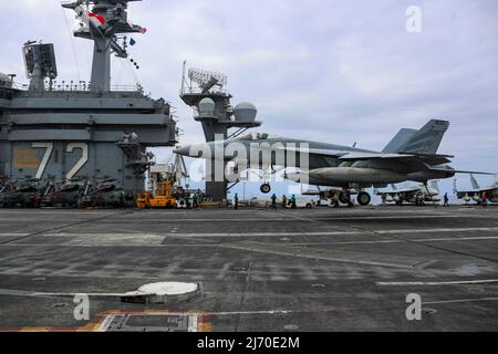 PHILIPPINISCHE SEE (19. April 2022) eine F/A-18E Super Hornet, die den „Vigilanten“ des Strike Fighter Squadron (VFA) 151 zugewiesen wurde, bereitet sich auf eine verhaftete Landung auf dem Flugdeck des Nimitz-Klasse-Flugzeugträgers USS Abraham Lincoln (CVN 72) vor. Die Abraham Lincoln Strike Group befindet sich im geplanten Einsatzgebiet der US-Flotte für 7., um die Interoperabilität durch Allianzen und Partnerschaften zu verbessern und gleichzeitig als reaktionsfähige Truppe zur Unterstützung einer freien und offenen Region im Indo-Pazifik-Raum zu dienen. (USA Navy Foto von Mass Communication Specialist 3. Class Javier Reyes) Stockfoto