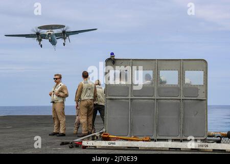 PHILIPPINISCHE SEE (19. April 2022) Landebeamte beobachten den Flugbetrieb auf dem Flugdeck des Flugzeugträgers USS Abraham Lincoln (CVN 72) der Nimitz-Klasse. Die Abraham Lincoln Strike Group befindet sich im geplanten Einsatzgebiet der US-Flotte für 7., um die Interoperabilität durch Allianzen und Partnerschaften zu verbessern und gleichzeitig als reaktionsfähige Truppe zur Unterstützung einer freien und offenen Region im Indo-Pazifik-Raum zu dienen. (USA Navy Foto von Mass Communication Specialist 3. Class Javier Reyes) Stockfoto