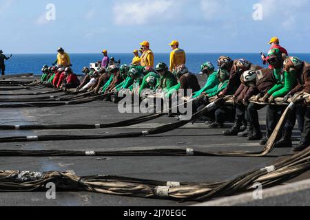 PHILIPPINISCHE SEEFAHRER (26. April 2022) haben während der Flugdecksübungen an Bord des Flugzeugträgers USS Abraham Lincoln (CVN 72) der Nimitz-Klasse eine Barrikade aufgestellt. Die Abraham Lincoln Strike Group befindet sich im geplanten Einsatzgebiet der US-Flotte für 7., um die Interoperabilität durch Allianzen und Partnerschaften zu verbessern und gleichzeitig als reaktionsfähige Truppe zur Unterstützung einer freien und offenen Region im Indo-Pazifik-Raum zu dienen. (USA Navy Foto von Mass Communication Specialist Seaman Kassandra Alanis) Stockfoto