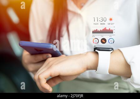 Smartwatch mit Gesundheitsdaten-Tracking per Smartphone für modernes digitales Lifestyle-Konzept Stockfoto