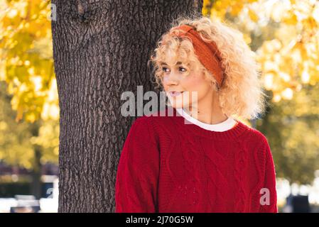 Hübsche junge blonde Frau unter dem Baum im Park Porträt Kopie Raum im Freien stehen. Hochwertige Fotos Stockfoto