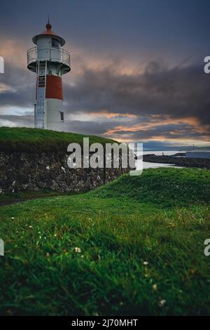 Alter Leuchtturm gegen unglaublichen Sonnenuntergang Himmel in der Altstadt von Torshavn, Hauptstadt der Färöer Inseln, Dänemark, Nordeuropa Stockfoto