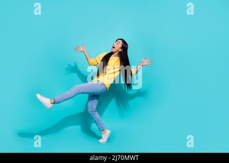 In voller Länge Foto von ziemlich beeindruckt Dame gekleidet gelb Pullover tanzen suchen leeren Raum isoliert türkis Farbe Hintergrund Stockfoto