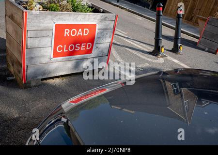 Die Motorhaube eines Autos wird fast bis zu einem 'Pflanzer' des LTN (Low Traffic Neighborhood) auf der Elsie Road geparkt, die vom Southwark Council initiiert wurde und Autofahrer daran hindert, am 5.. Mai 2022 in London, England, East Dulwich Grove in East Dulwich, SE22, zu erreichen. Das LTN-Programm in East Dulwich und Dulwich Village war zwischen Pro-Rad- und Motoringgruppen sehr umstritten. Stockfoto