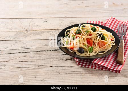 Spaghetti mit Gemüse (Brokkoli, Tomaten, Paprika) auf Holztisch Stockfoto