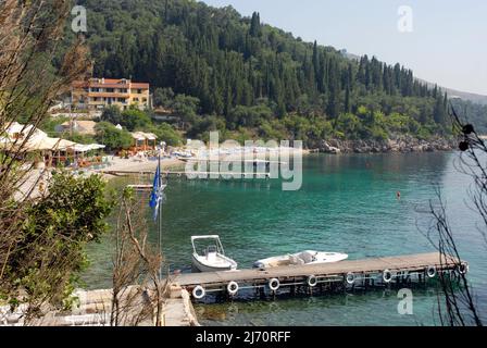 Ruhige Bucht im Osten von Korfu, Griechenland, wo sich die Leute am Strand entspannen Stockfoto