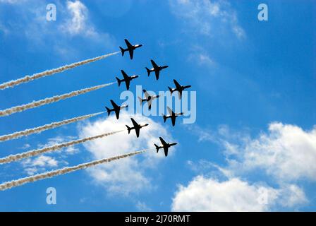 Rote Pfeile zeigen Team, das in der Diamond Nine Formation bei der Airshow in Biggin Hill, England, weißen Rauch nachlässt Stockfoto