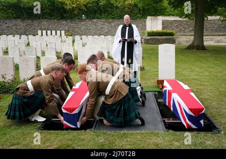 Eine Trägerpartei des Royal Regiment of Scotland trägt den Sarg des Private William Johntson, Bataillon 7., Royal Scots Fusiliers, während er neben einem unbekannten Soldaten des East Yorkshire Regiments auf dem Loos British Cemetery der Commonwealth war Graves Commission (CWGC), Loos-en-Gohelle, Frankreich, mit vollen militärischen Ehren begraben wird. Bilddatum: Donnerstag, 5. Mai 2022. Stockfoto