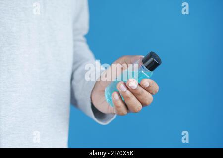 Halten Sie einen Behälter für Mundwasser mit der Hand Stockfoto