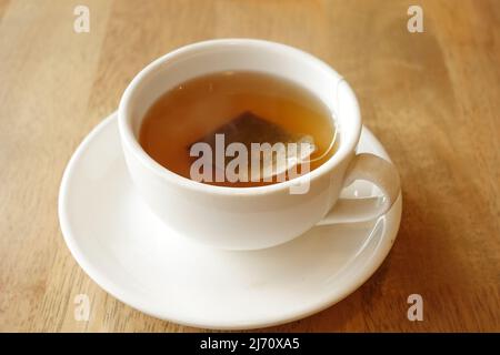 Grüner Tee mit Teebeutel auf Fliesen Hintergrund Stockfoto
