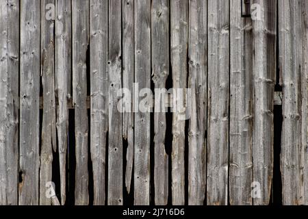 Verwitterter und beschädigter Holzpaneelhintergrund, alte Stallfassade Stockfoto