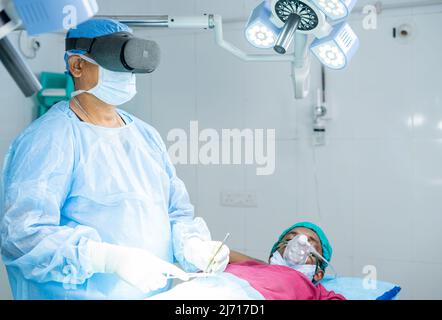 Chirurg operiert Chirurgie mit VR-Brille im Krankenhaus Operationssaal zeigt mit Kopierraum - Konzept der modernen Gesundheitstechnologie, vitual Stockfoto