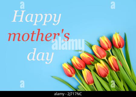 Tulpen sind rot-gelb, auf blauem Hintergrund und der Text HAPPY MOTHER'S DAY . Stockfoto