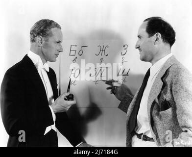 LESLIE HOWARD am Set offen Russisch lernen von Technical Director NICHOLA KOBLIANSKY während der Dreharbeiten des BRITISCHEN AGENTEN 1934 Regisseur MICHAEL CURTIZ Buch R.H. Bruce Lockhart First National Pictures / Warner Bros. Stockfoto