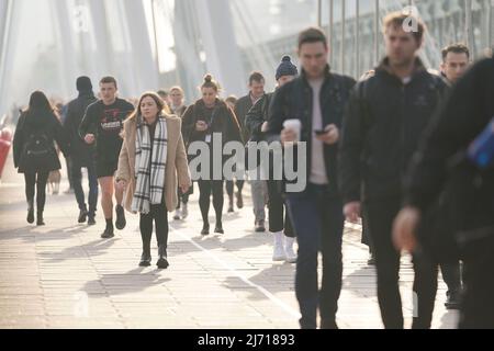 Aktenfoto vom 07/03/22 von Pendlern, die die Golden Jubilee Bridge in London überqueren. Die steigenden Reisekosten haben dazu geführt, dass viele Arbeitnehmer überdenken, ins Büro zu pendeln, obwohl sich die Dinge im Winter aufgrund der hohen Heizkosten ändern könnten, so neue Untersuchungen. Ausgabedatum: Donnerstag, 5. Mai 2022. Stockfoto