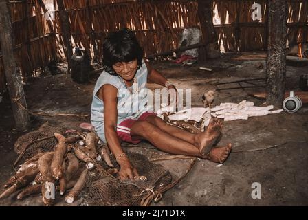 Indigene Frau aus dem Stamm der Arara do Laranjal im brasilianischen Amazonas, die Maniok schält. Xingu River, 2007. Stockfoto