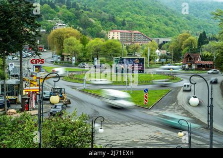 Dilijan, Armenien - 5. Mai 2022 - Autos fahren durch den Kreisverkehr in Dilijan, Armenien, mit langsamer Verschlusszeit Stockfoto