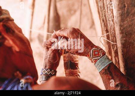 Ein indischer Mann, der einen Kokaberaufschmuck aus Federn basteln soll. Rio Xingu, September 2010. Stockfoto