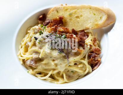 Spaghetti Carbonara mit knusprigen Bacons und Knoblauchbrot Stockfoto