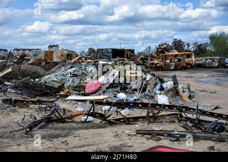 BUCHA, UKRAINE - 4. MAI 2022 - Autos, die durch russischen Beschuss beschädigt wurden, werden auf einem Autofriedhof in Bucha, Region Kiew, nördlicher Ukrain gelagert Stockfoto