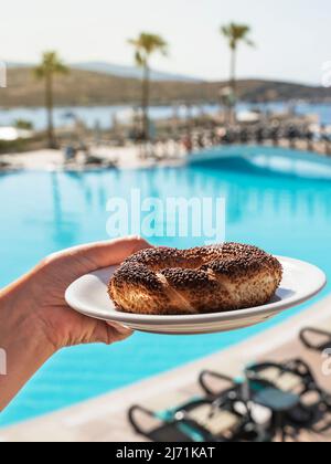 Die Frau hält einen Bagel in der Hand. Nationaler Charakter. Vertikal. Stockfoto