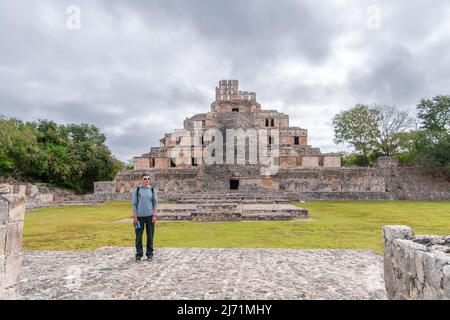 Touristenmann posiert vor den maya-Ruinen der Edzna-Pyramide (Tempel der fünf Stockwerke) in archäologischer Ausgrabungsstätte auf der Halbinsel Yucatan, Mexiko. Stockfoto