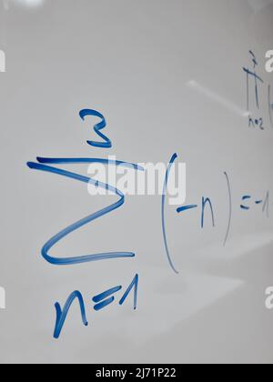 Mathematische Symbole einer Gleichung aus einem Mathematikvortrag auf einem Whiteboard Stockfoto