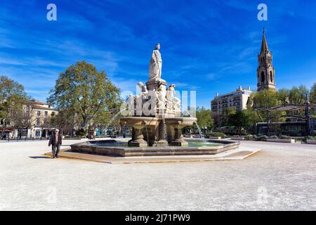 Fontaine Pradier, großer Brunnen auf dem Platz Esplanade Charles-de-Gaulle, Glockenturm der Kirche Sainte-Perpetue und Sainte-Felicite, Nimes Stockfoto