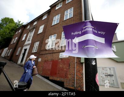 London, Großbritannien. 5. Mai 2022. (220505) -- LONDON, 5. Mai 2022 (Xinhua) -- Eine Frau kommt am 5. Mai 2022 an einem Schild eines Wahllokalen in London, Großbritannien, vorbei. Wahllokale in ganz Großbritannien wurden am frühen Donnerstag eröffnet, als die Wähler für Kommunalwahlen anreisten. (Xinhua/Li Ying) Quelle: Xinhua/Alamy Live News Stockfoto