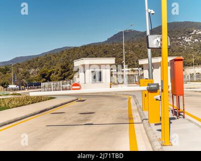 Bewachter Eingang zum Parkplatz mit einer automatischen Barriere, einer Sicherheitskabine. Sicherheitssystem. Stockfoto