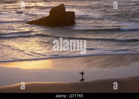 Surfer mit Surfbrett Spaziergänge entlang Praia do Tonel, Sagres, Portugal Stockfoto