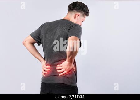 Mann mit Wirbelsäulenproblemen, Person mit Rückenproblemen auf isoliertem Hintergrund, Konzept mit Lendenwirbelproblemen, ein wund Mann mit Rückenschmerzen Stockfoto