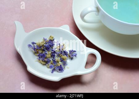 Getrocknete Malvenblueten in Schaelchen und Tasse Malvenbluetentee Stockfoto