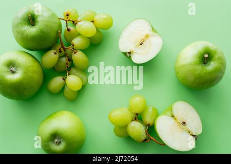 Draufsicht auf Äpfel und reife Trauben auf Grün Stockfoto