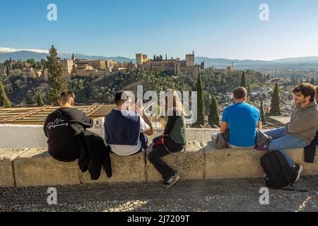 Touristen im Mirador San Nicolas Brüstungsterrasse in der Albaicin mit Alhambra im Hintergrund. Granada, Andalusien, Spanien Stockfoto