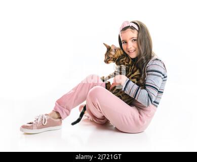 Kleines Mädchen hält bengalkatze isoliert auf weißem Hintergrund Stockfoto